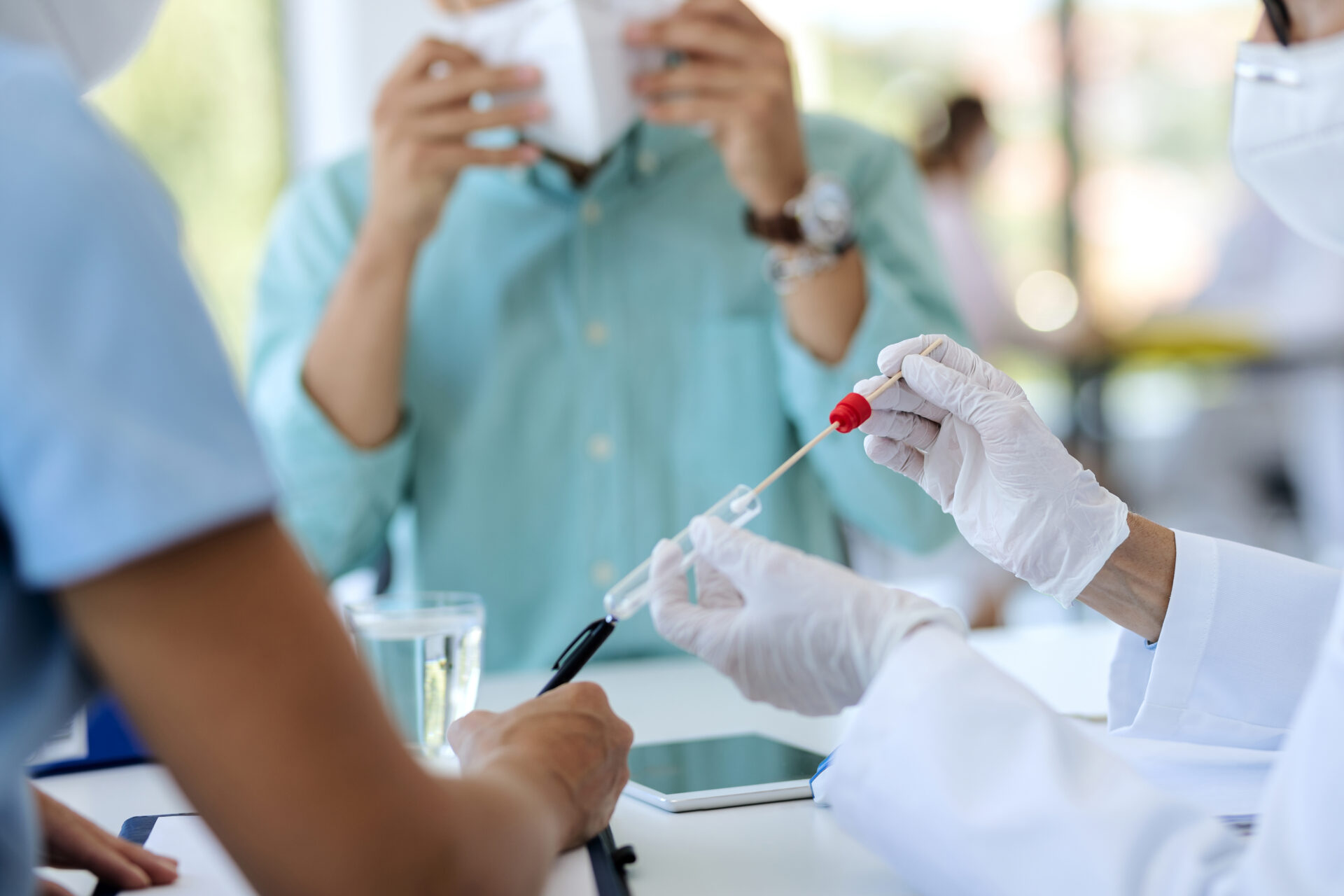 Close-up of a doctor using cotton swab for PCR test during medical appointment.